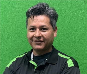 Male in black shirt on green wall