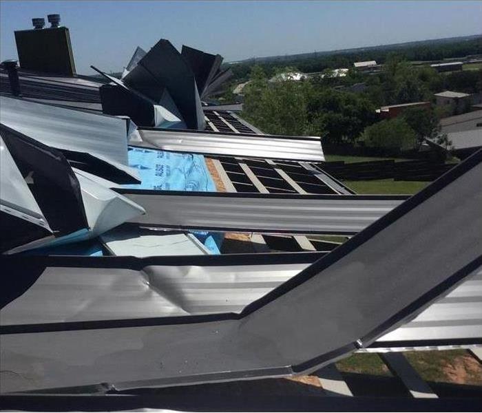 Sheet metal on a roof damaged by heavy winds.